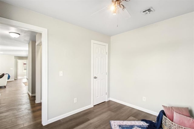 sitting room with dark wood-style flooring, visible vents, ceiling fan, and baseboards