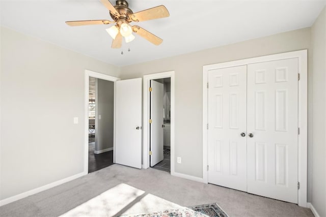 unfurnished bedroom with a closet, light carpet, ensuite bath, and baseboards