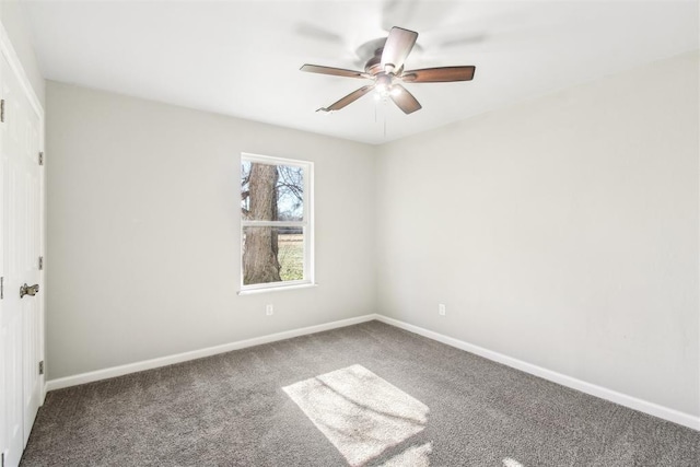 carpeted spare room with ceiling fan and baseboards