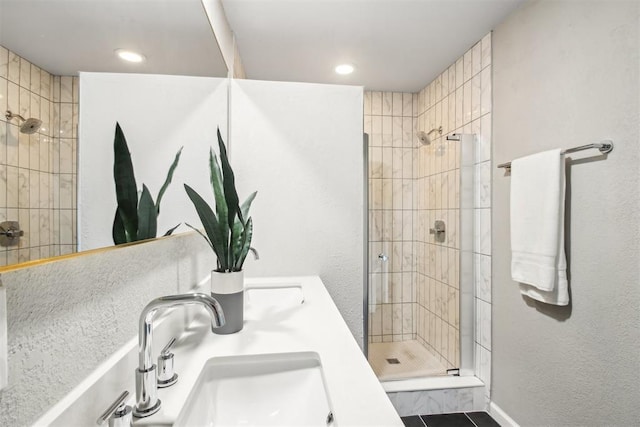 full bath featuring double sink and a shower stall