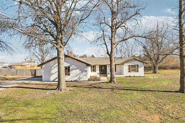 view of front of house featuring a front lawn, fence, and brick siding