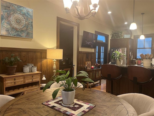 interior space with wooden walls, a chandelier, and ornamental molding