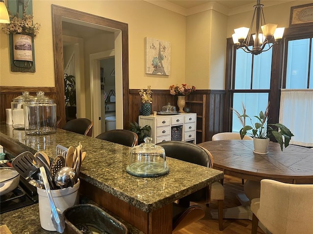 dining space featuring crown molding, hardwood / wood-style floors, and an inviting chandelier