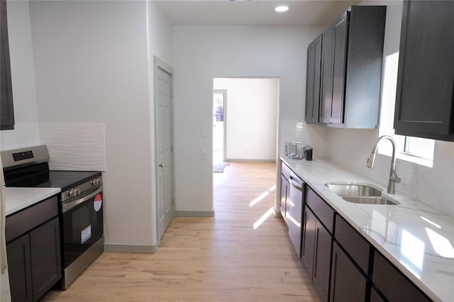 kitchen featuring light hardwood / wood-style floors, stainless steel appliances, backsplash, light stone countertops, and sink