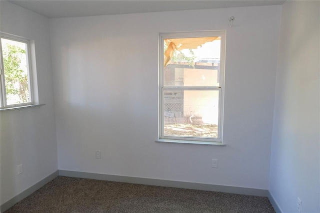 spare room featuring dark carpet