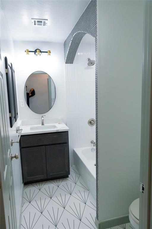 full bathroom featuring washtub / shower combination, toilet, and vanity