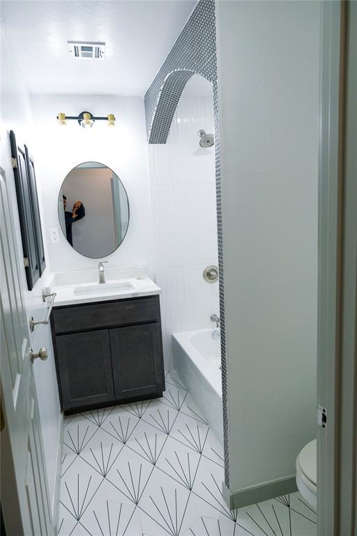 full bathroom featuring toilet, vanity, and  shower combination