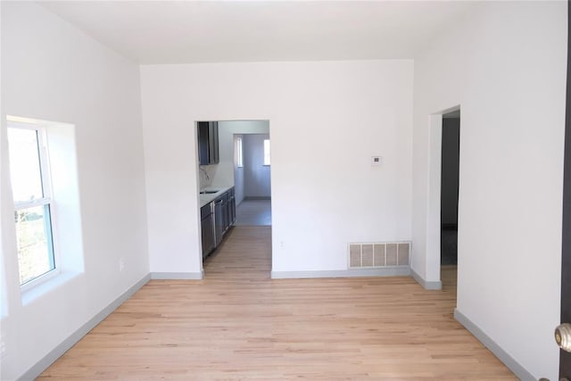 empty room featuring sink and light hardwood / wood-style floors