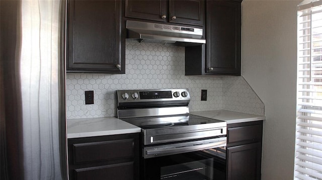 kitchen featuring decorative backsplash, dark brown cabinets, stainless steel electric range oven, and light stone countertops