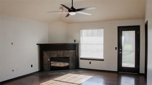 unfurnished living room featuring ceiling fan, a fireplace, and dark wood-type flooring