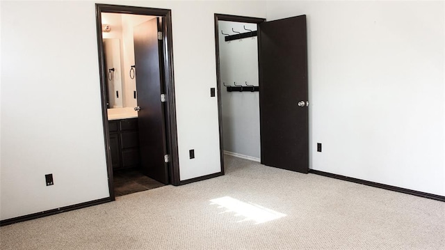 unfurnished bedroom featuring carpet floors and ensuite bath