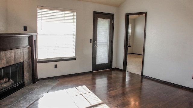 interior space with a fireplace, dark wood-type flooring, and vaulted ceiling