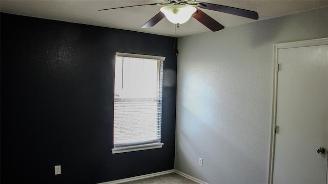 carpeted spare room with a wealth of natural light and ceiling fan