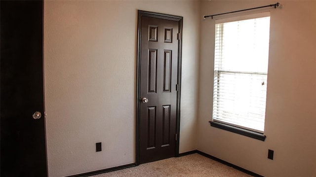 unfurnished room featuring light colored carpet