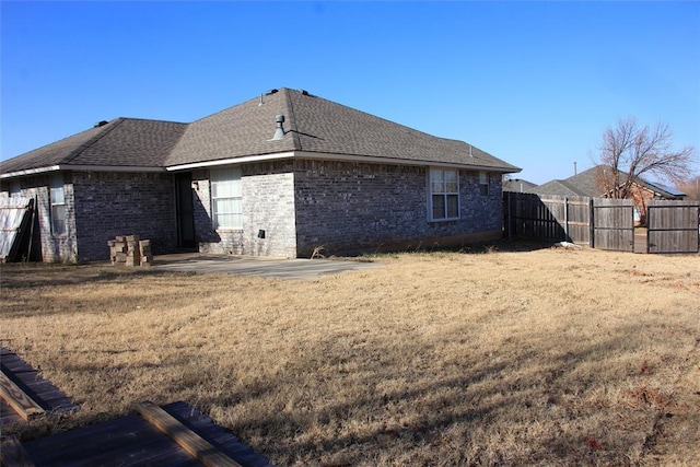 back of property with a yard and a patio area