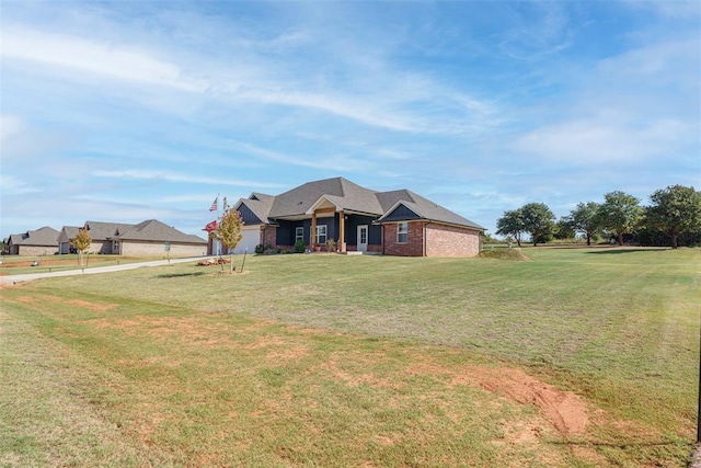 view of front of property featuring brick siding, an attached garage, and a front lawn