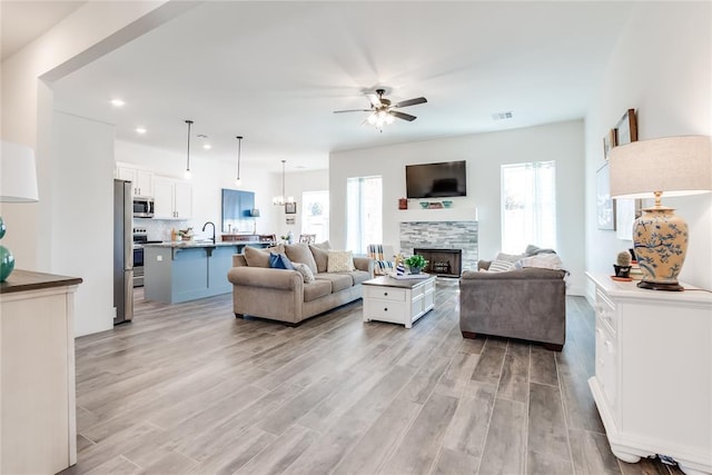 living area with light wood-type flooring, plenty of natural light, and a fireplace