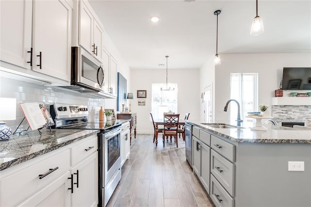 kitchen featuring light stone countertops, backsplash, stainless steel appliances, and a sink