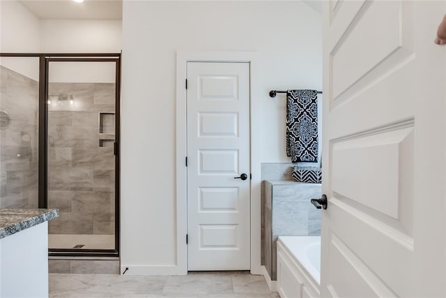 bathroom featuring a shower stall, baseboards, and a bath