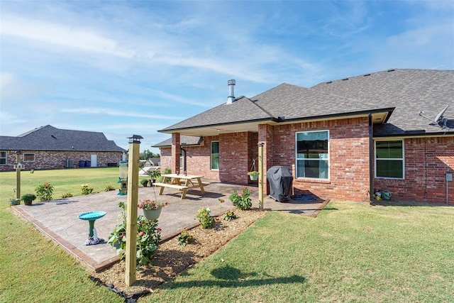 rear view of house featuring a patio, brick siding, and a lawn