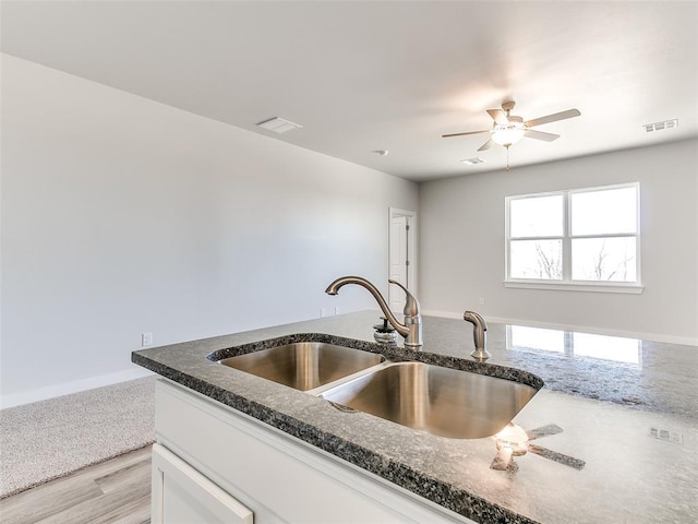 13074 Mannington Rd, Edmond, OK 73025 - kitchen featuring dark stone countertops, a ceiling fan, white cabinetry, and light wood-style flooring