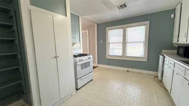 kitchen with white gas stove and white cabinets