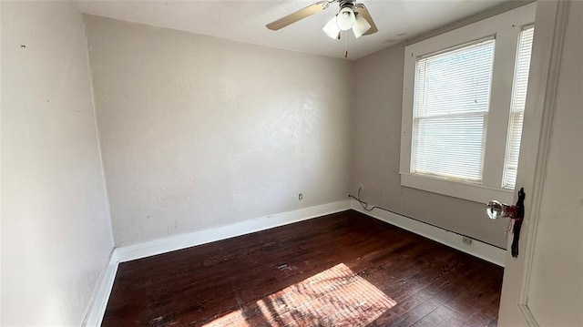 spare room with dark hardwood / wood-style flooring and ceiling fan