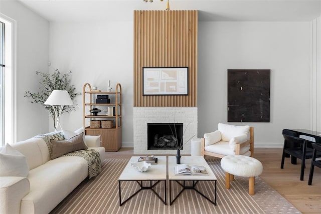 living room with hardwood / wood-style flooring and a brick fireplace