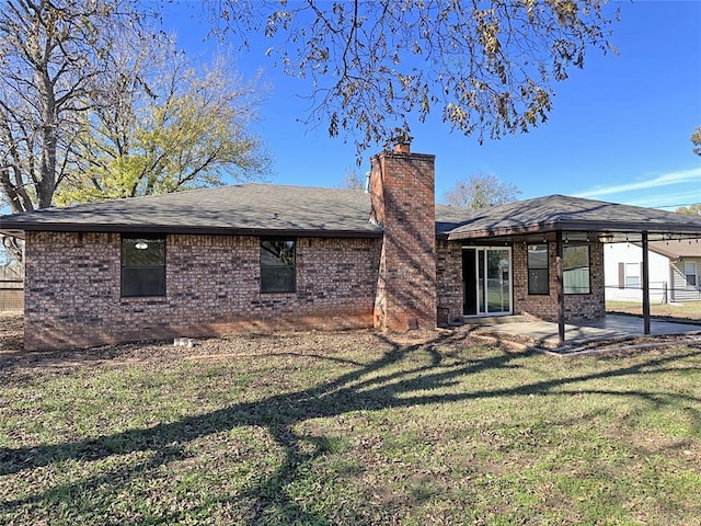 rear view of house with a patio and a lawn