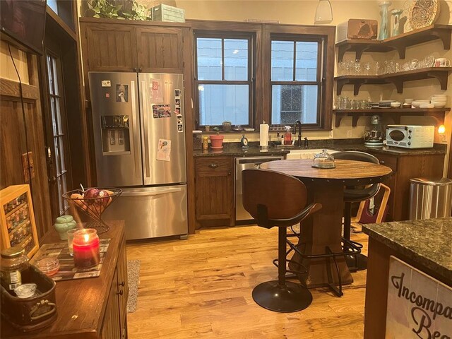 kitchen with stainless steel appliances, sink, and light hardwood / wood-style floors