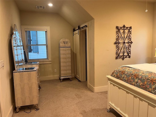 carpeted bedroom with vaulted ceiling and a barn door