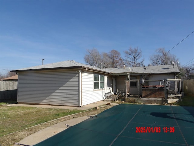 rear view of house with a patio and a pool with hot tub