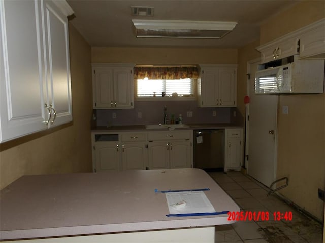 kitchen featuring stainless steel dishwasher, light tile patterned flooring, white cabinetry, and sink