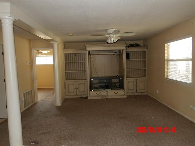 unfurnished living room featuring ceiling fan, ornate columns, light carpet, and heating unit