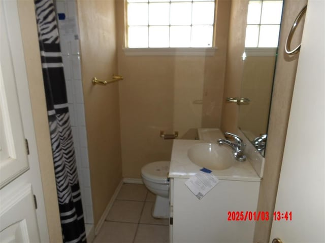 bathroom with tile patterned flooring, vanity, and toilet