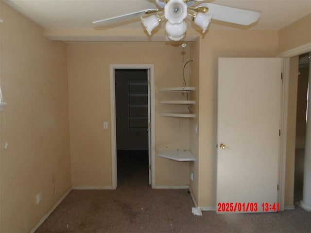 unfurnished bedroom featuring a closet, a walk in closet, carpet floors, and ceiling fan