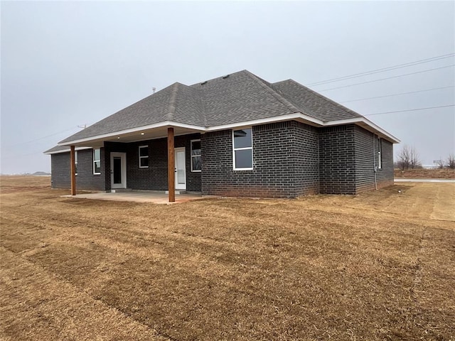 rear view of house with a yard and a patio