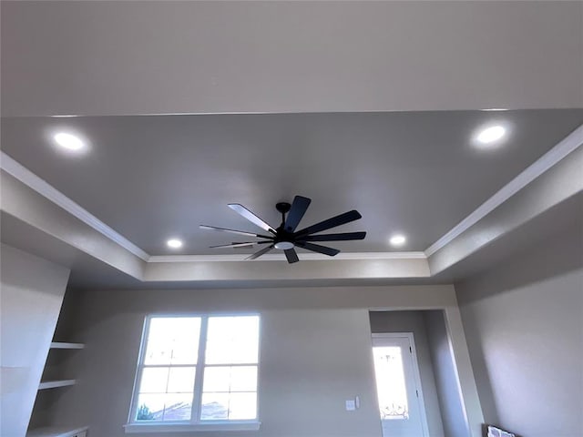 details featuring built in shelves, ceiling fan, ornamental molding, and a tray ceiling