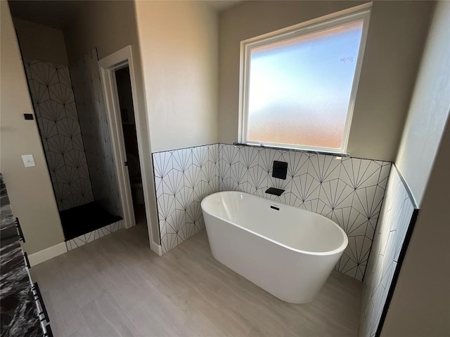 bathroom with hardwood / wood-style flooring, plus walk in shower, and tile walls