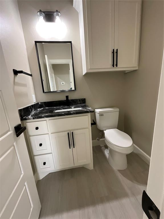 bathroom with vanity, hardwood / wood-style floors, and toilet