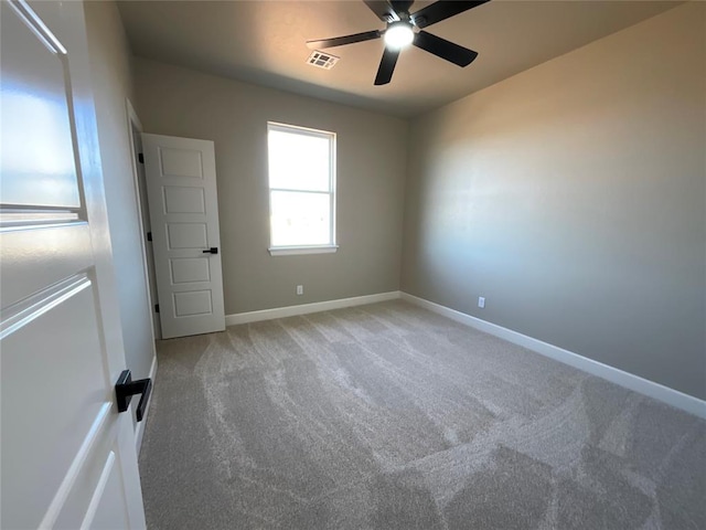 empty room featuring visible vents, baseboards, light colored carpet, and a ceiling fan