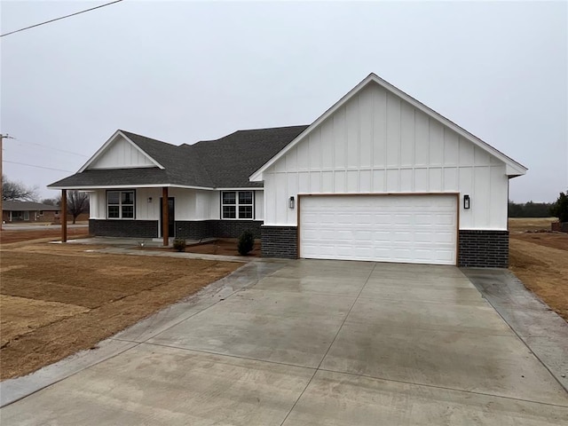 ranch-style house with roof with shingles, board and batten siding, an attached garage, and brick siding