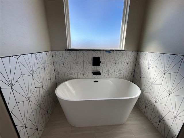 bathroom with a freestanding bath and tile walls
