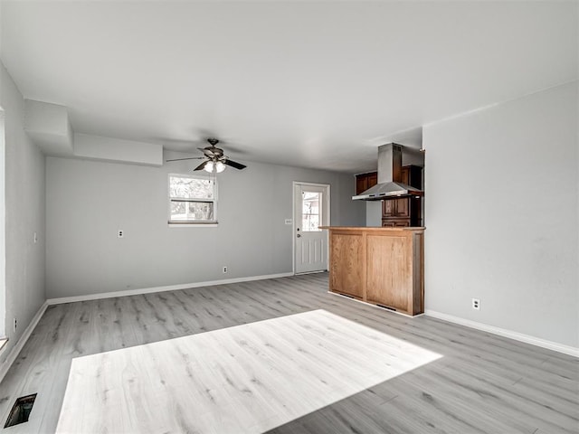 unfurnished living room featuring ceiling fan and light wood-type flooring