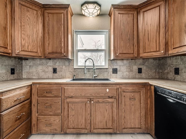 kitchen featuring decorative backsplash, dishwasher, and sink