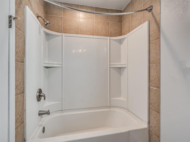 bathroom featuring shower / bathtub combination and a textured ceiling