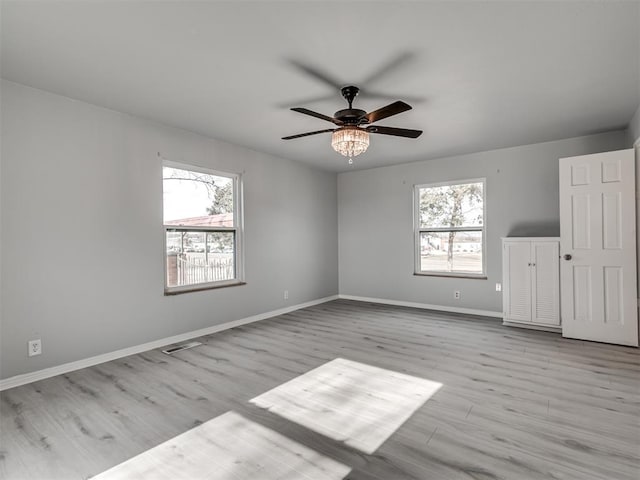 spare room with ceiling fan, plenty of natural light, and light hardwood / wood-style flooring