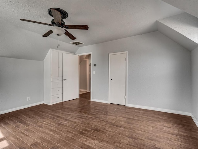 additional living space with a textured ceiling, hardwood / wood-style flooring, ceiling fan, and lofted ceiling