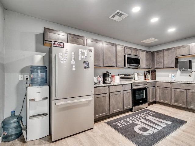 kitchen with recessed lighting, light wood-type flooring, visible vents, and stainless steel appliances