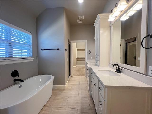 4309 NW 152nd Pl, Edmond, OK 73013 - full bath with vanity, a freestanding tub, a spacious closet, baseboards, and a stall shower
